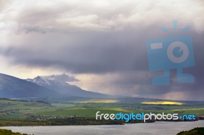 Town On The Lake Behind The Foothills. Spring Rain And Storm In Stock Photo