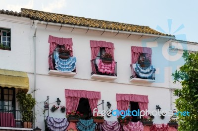 Traditional Spanish Dresses Adorning Balconies On A Building In Stock Photo