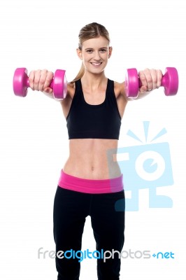 Trainer Holding Dumbbells In Her Outstretched Arms Stock Photo