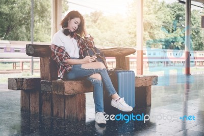 Traveler Girl Using Tablet With A Luggage Sitting And Waiting Fo… Stock Photo