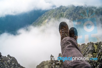 Trekker Over The Clouds In The Mountains Stock Photo