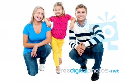 Trendy Couple Squatting With Girl Child In Between Stock Photo