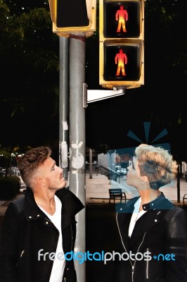 Trendy Young Couple Looking At The Traffic Light Stock Photo