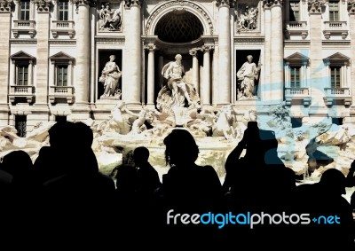 Trevi Fountain And Tourists Shooting Stock Photo