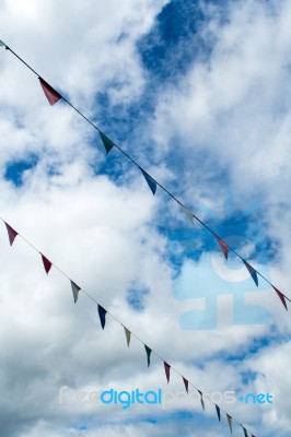 Triangle Flag Hanging On The Rope And Blue Sky Stock Photo