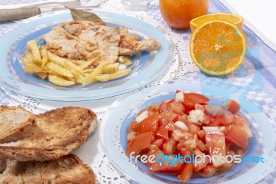 Turkey Steak With French Fries And Tomato Salad Stock Photo