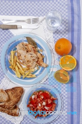 Turkey Steak With French Fries And Tomato Salad Stock Photo