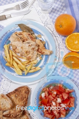 Turkey Steak With French Fries And Tomato Salad Stock Photo