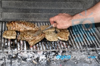 Turning Steaks And Ribs On Bbq Stock Photo