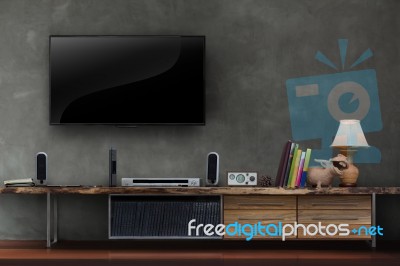 Tv On Concrete Wall With Wooden Media Furniture Stock Photo