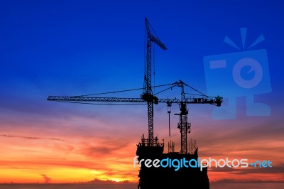 Twilight And Silhouette Construction With Crane On Top Building Stock Photo