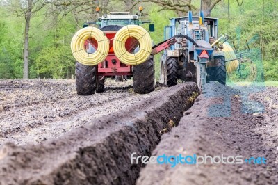 Two Agriculture Tractors Putting Drainage Pipes In Ground Stock Photo