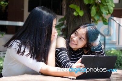 Two Asia Thai High School Student Best Friends Beautiful Girl Using Her Tablet And Funny Stock Photo