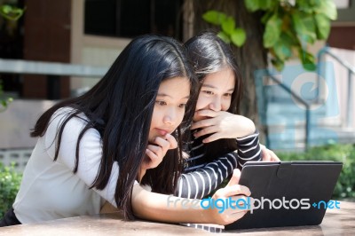 Two Asia Thai High School Student Best Friends Beautiful Girl Using Her Tablet And Funny Stock Photo