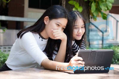 Two Asia Thai High School Student Best Friends Beautiful Girl Using Her Tablet And Funny Stock Photo