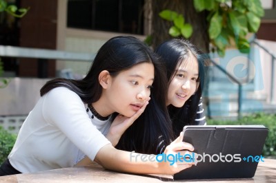 Two Asia Thai High School Student Best Friends Beautiful Girl Using Her Tablet And Funny Stock Photo