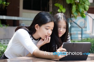 Two Asia Thai High School Student Best Friends Beautiful Girl Using Her Tablet And Funny Stock Photo