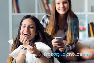 Two Beautiful Young Woman Staying On Sofa At Home Stock Photo