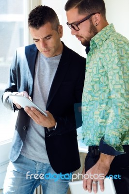 Two Businessman Using Digital Tablet In Office Stock Photo