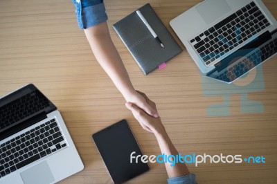 Two Businesspeople Shaking Hands Indoors Stock Photo