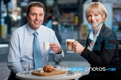 Two Corporates Discussing Business Over Snacks Stock Photo