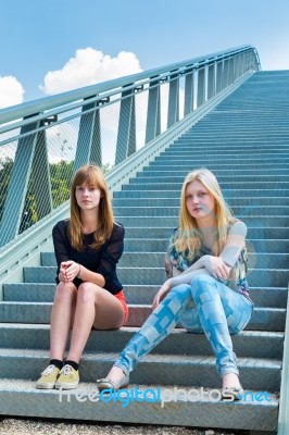 Two Dutch Girls Sitting On Metal Bridge Stock Photo