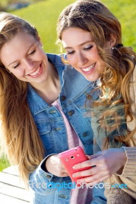 Two Friends Having Fun With Smartphones Stock Photo