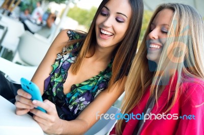 Two Friends Having Fun With Smartphones Stock Photo