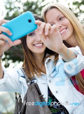 Two Friends Taking Photos With A Smartphone Stock Photo