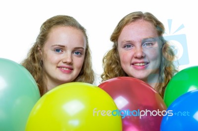 Two Girls Behind Various Colored Balloons Stock Photo