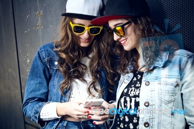 Two Girls Having Fun With Smartphones Stock Photo