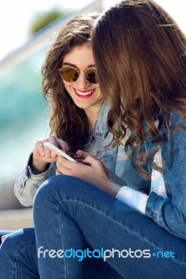 Two Girls Having Fun With Smartphones Stock Photo