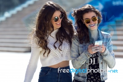 Two Girls Having Fun With Smartphones Stock Photo