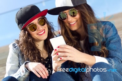 Two Girls Having Fun With Smartphones Stock Photo