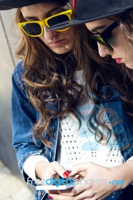 Two Girls Having Fun With Smartphones Stock Photo