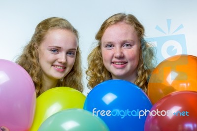 Two Girls Heads Behind Colored Balloons Stock Photo