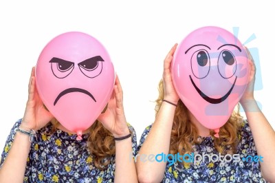 Two Girls Holding Pink Balloons With Facial Expressions Stock Photo