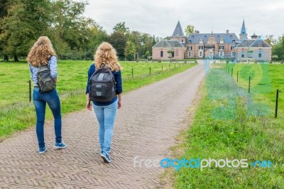 Two Girls Walking On Road Leading To Castle Stock Photo