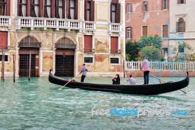 Two Gondoliers Ferrying Passengers Along The Canals Of Venice Stock Photo