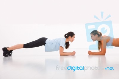 Two Happy Young Woman Doing Push-ups In Gym Stock Photo