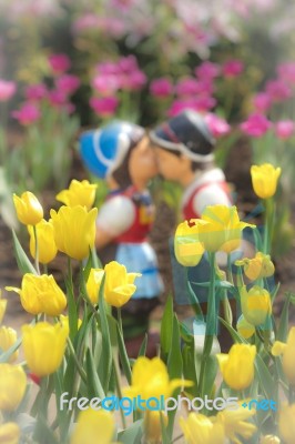 Two Kissing Dolls In Tulip Garden Stock Photo