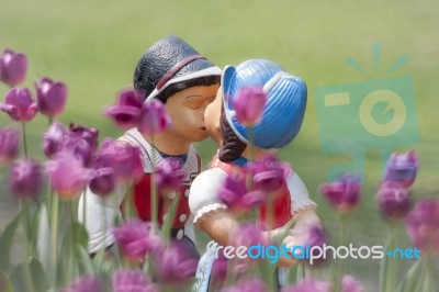 Two Kissing Dolls In Tulip Garden Stock Photo