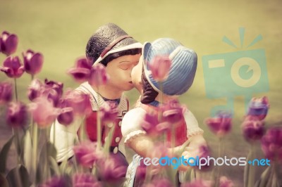 Two Kissing Dolls In Tulip Garden Stock Photo