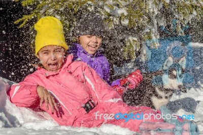 Two Little Girls Playing In The Snow With Husky Dog Stock Photo