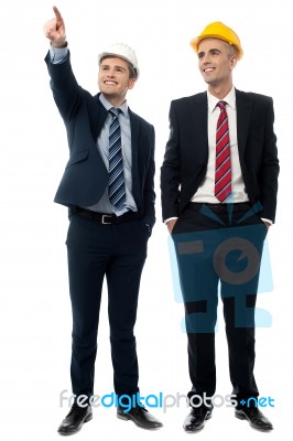 Two Men In Hard Hats Looking Away Stock Photo