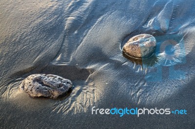 Two Rocks In Volcanic Sand Stock Photo