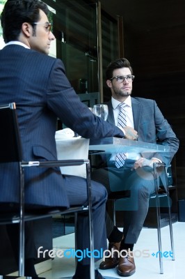 Two Smiling Business Men Have Dinner At Restaurant Stock Photo