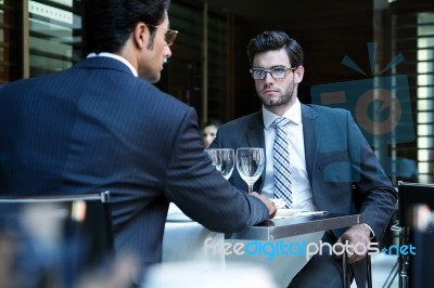 Two Smiling Business Men Have Dinner At Restaurant Stock Photo