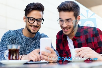 Two Young Entrepreneurs Working At Coffee Shop Stock Photo