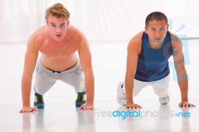 Two Young Man Doing Push-ups In Gym Stock Photo